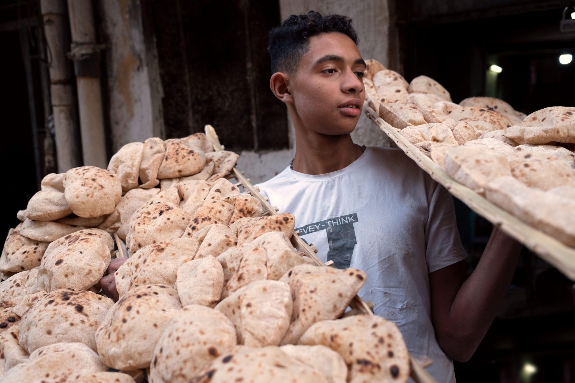 A young man delivers bread in Cairo, Egypt; the price of subsidised bread will rise for the first time in 30 years