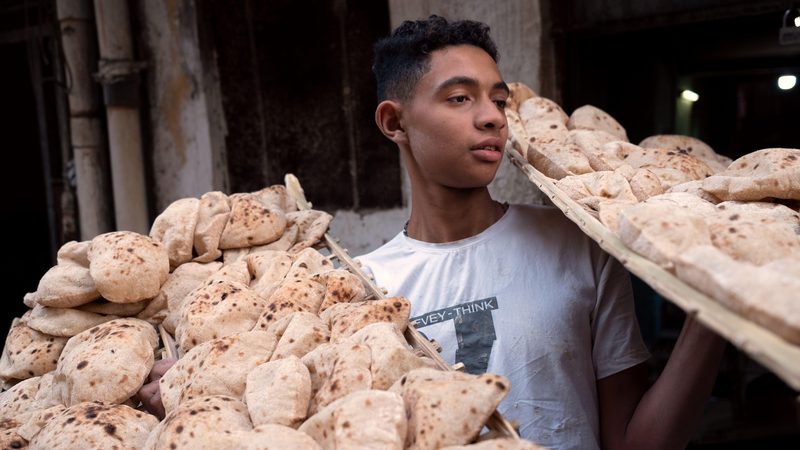 A young man delivers bread in Cairo, Egypt; the price of subsidised bread will rise for the first time in 30 years