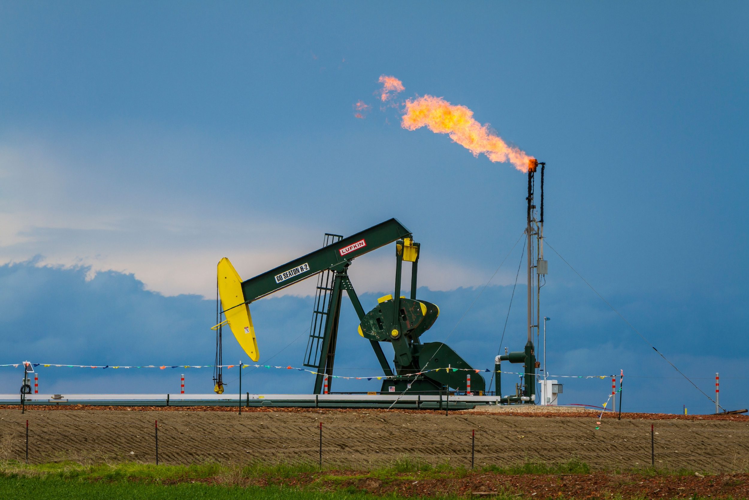 DG8B0G Natural gas flaring and a pumper in the Bakken shale oil fields near Williston, North Dakota, USA.
