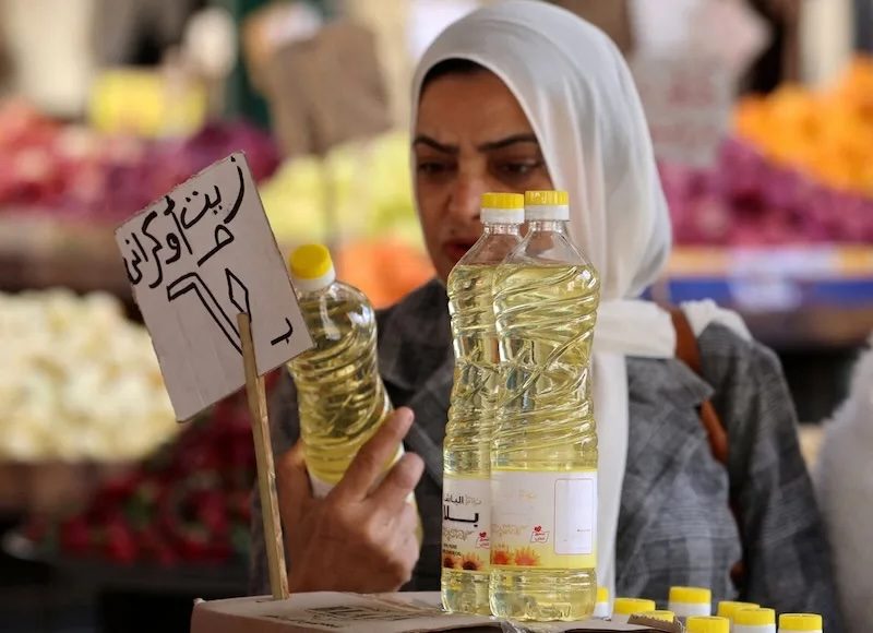 A woman buys cooking oil at a market in downtown Cairo. Falling food prices contributed to the drop in inflation in Egypt