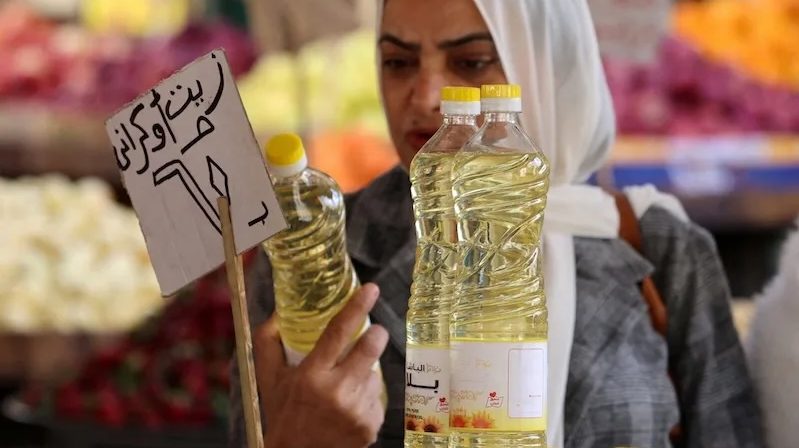 A woman buys cooking oil at a market in downtown Cairo. Falling food prices contributed to the drop in inflation in Egypt