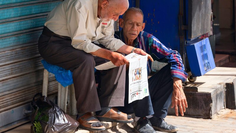 Men in Amman, Jordan reading a newspaper. Publications are under financial pressure in the absence of a big subsidising owner