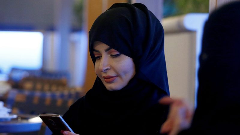 A woman uses her mobile phone in a Riyadh cafe. According to data, Saudi Arabians spend five hours a day on their smartphones