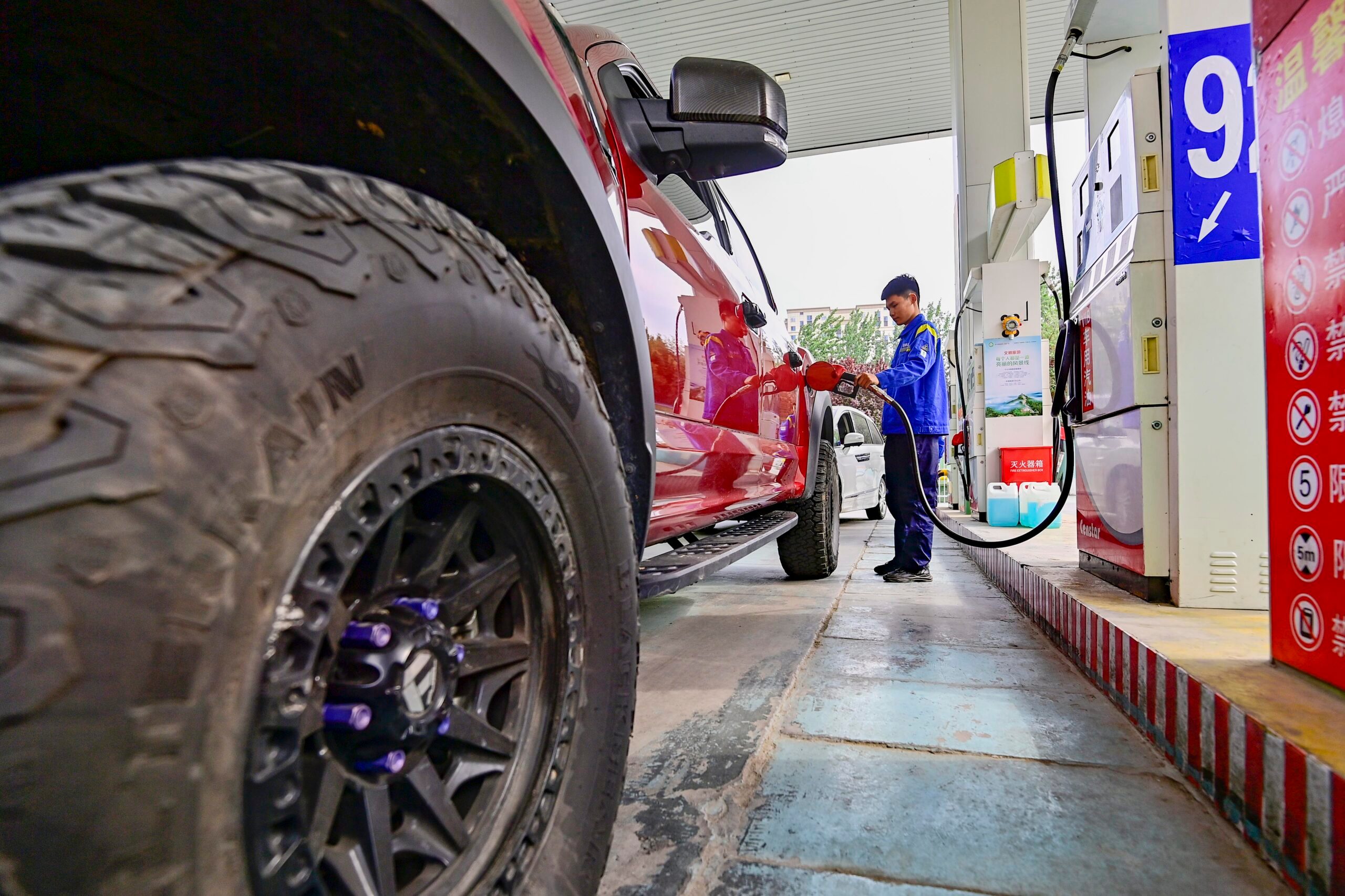 A worker fills up a car at a petrol station in Qingzhou, Shandong province. Electric vehicles are a contributing factor to the fall in Chinese oil demand