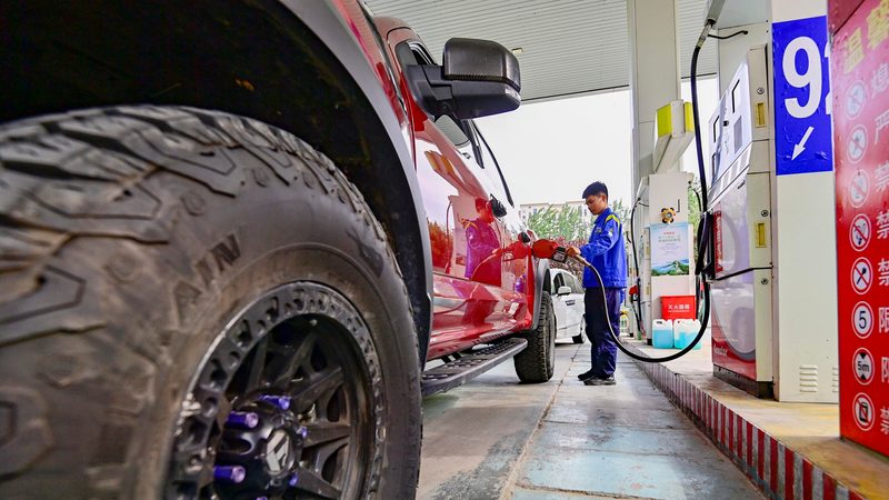 A worker fills up a car at a petrol station in Qingzhou, Shandong province. Electric vehicles are a contributing factor to the fall in Chinese oil demand