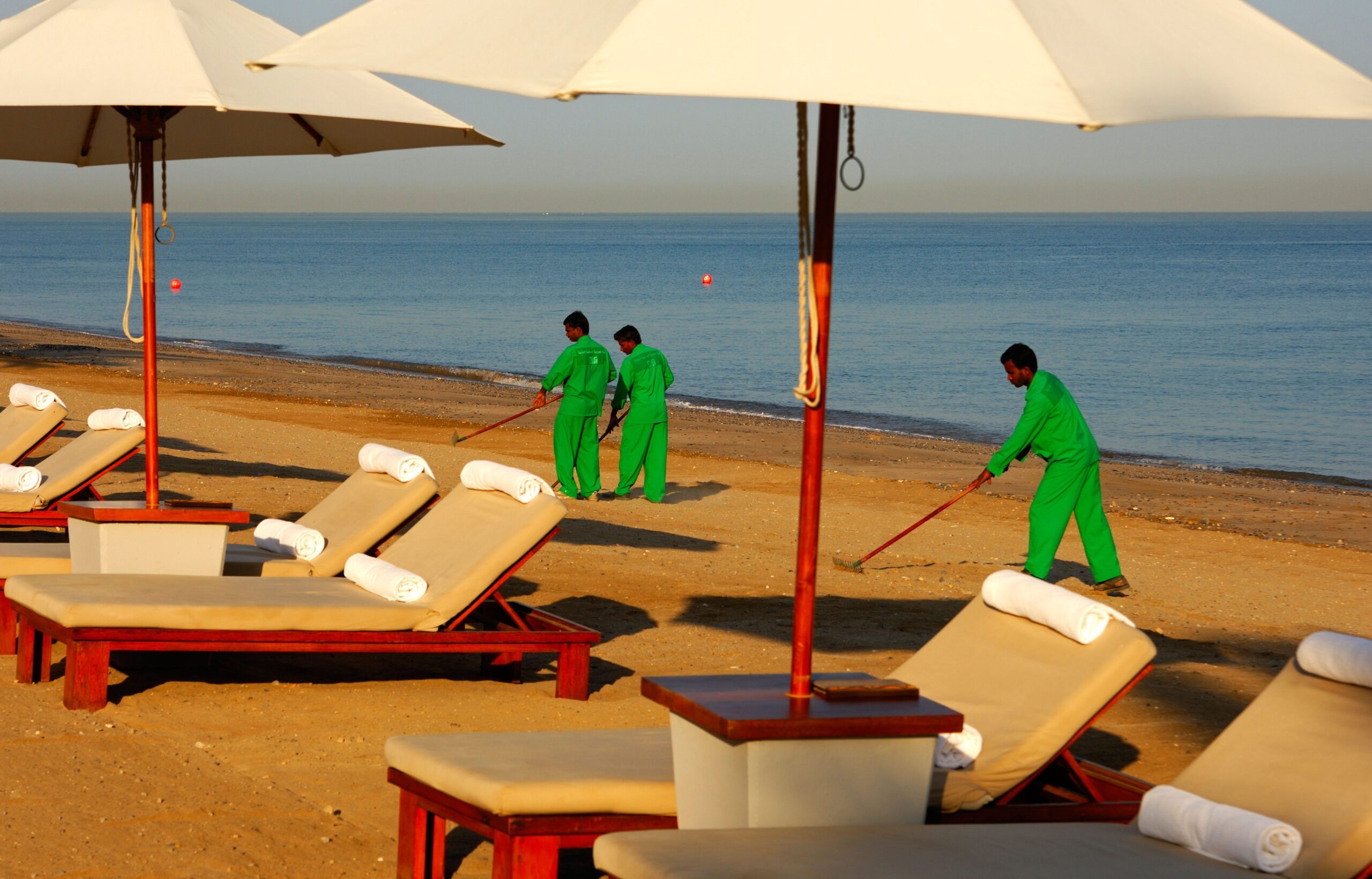 Guest workers from South East Asia cleaning the beach in front of a hotel in Muscat, Oman. The sultanate's private sector often turns to expatriates to fill vacancies that nationals do not apply for, and there are fears about unemployment