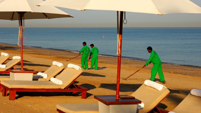Guest workers from South East Asia cleaning the beach in front of a hotel in Muscat, Oman. The sultanate's private sector often turns to expatriates to fill vacancies that nationals do not apply for, and there are fears about unemployment