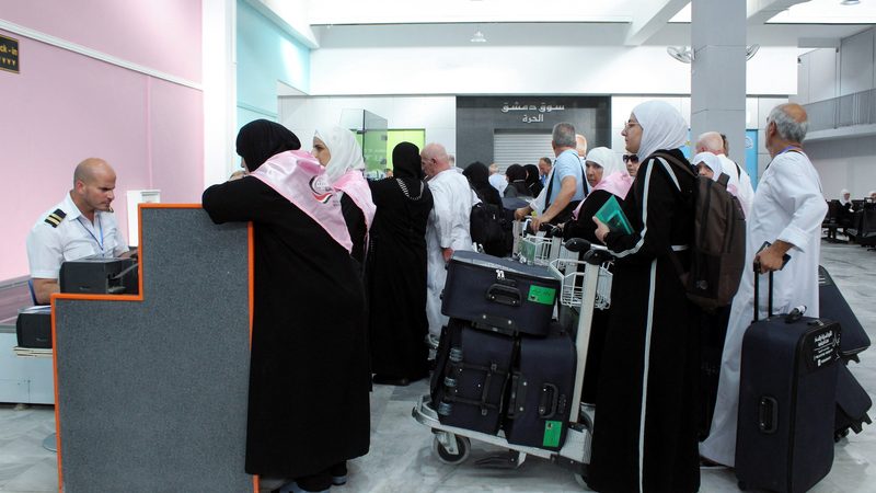 Syrian pilgrims queue at Damascus airport on their way to visit Saudi Arabia in June