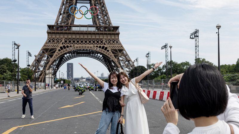 Paris 2024 Olympics - Paris 2024 Olympics Preview - Paris, France - July 18, 2024 People pose for a picture in front of the Eiffel tower ahead of Paris 2024 REUTERS/Marko Djurica