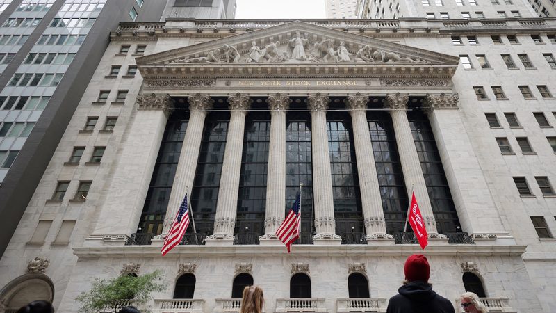 FILE PHOTO: People look toward the New York Stock Exchange (NYSE) before the Federal Reserve announcement in New York City, U.S., September 18, 2024. REUTERS/Andrew Kelly/File PhotoPeople await the announcement of the Fed decision on interest rates outside the New York Stock Exchange; Gulf banks followed suit, lowering rates