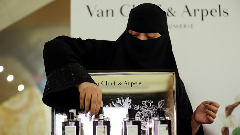 A woman arranges luxury fragrance in a Riyadh mall; Saudi Arabia hopes to increase tourist spending with a tax refund scheme