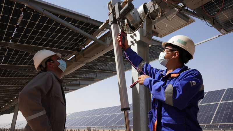 Workers check solar panels in Basra, Iraq. Renewable energy projects are growing across the Middle East