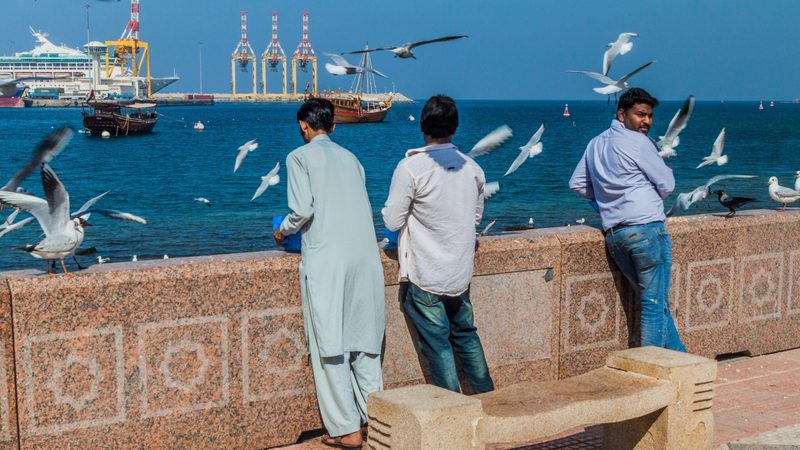 Men on the Muscat waterfront. Omani citizens who earn more than $1m will have to pay income tax