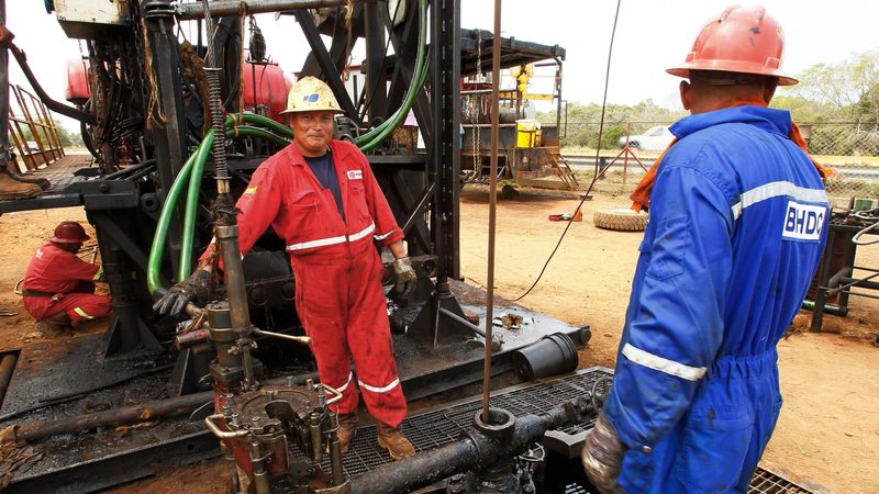 Opec+ no-win. Oil workers in Lagunillas. Venezuela, along with Iran and Libya, is exempt from Opec production cuts