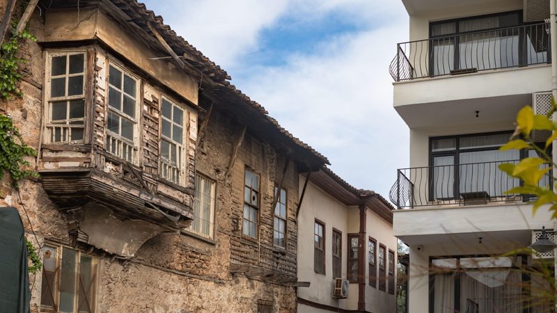 Antalya, Turkey - This photograph captures the contrast between the traditional Ottoman-style house and the modern apartment building in Kaleici, the Old Town of Antalya.