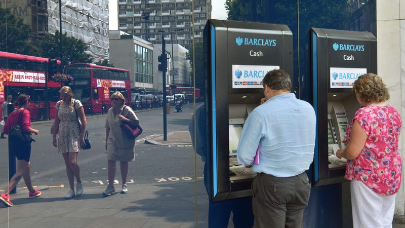 Customers use ATMs at a Barclays branch in London. Qatari investors helped the bank avoid a state bailout