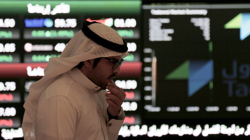 A Saudi man walks at the Tadawul Saudi Stock Exchange, in Riyadh, Saudi Arabia