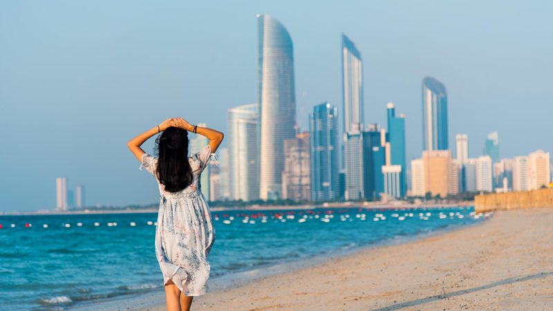 Female tourist on Abu Dhabi city beach with a view