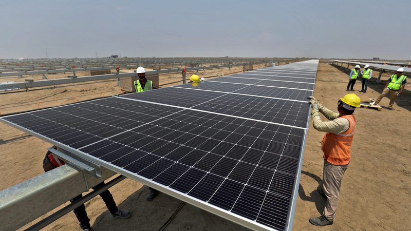 Workers at an Adani solar plant. IHC says it is confident in the company's contributions to renewable energy