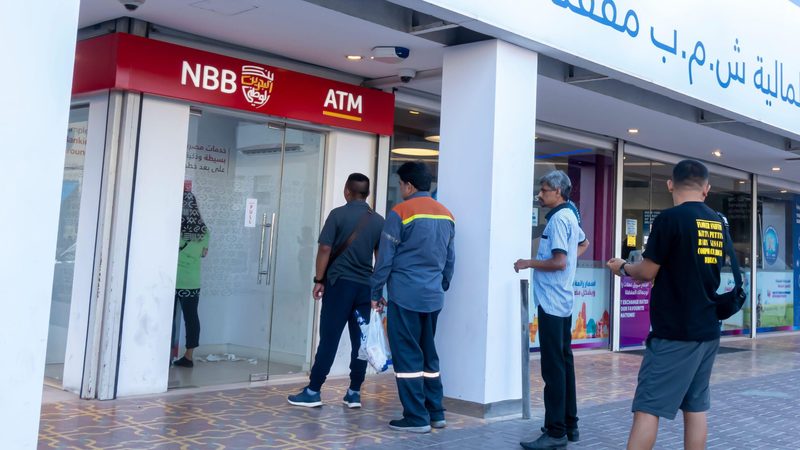 People queueing to use a National Bank of Bahrain ATM in Manama. The merger with Bank of Bahrain and Kuwait was announced this year