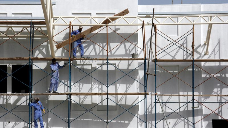 Workers erect scaffolding on a construction site in Manama, Bahrain