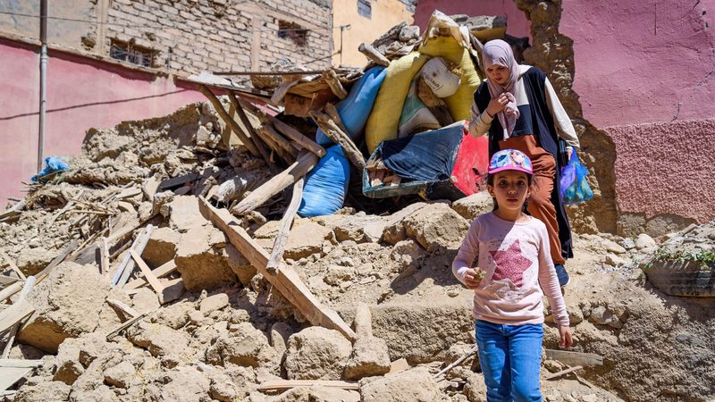 A mother and daughter leave their destroyed house in Amizmiz, Morocco. The EU is to increase its total earthquake aid to €1bn