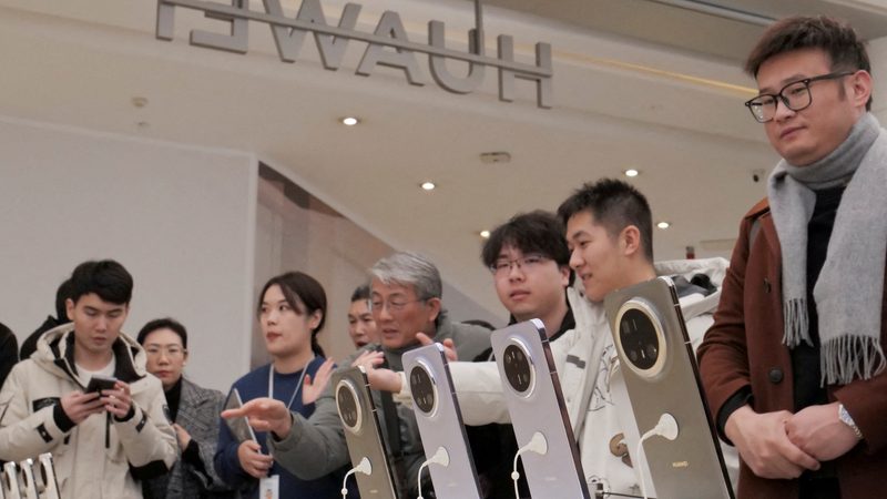 Shoppers admire Huawei's Mate 70 smartphone series at a flagship store in Beijing, China. Huawei is is banned in the US but expanding 5G networks in the GCC