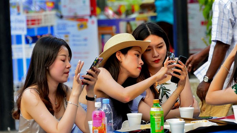 People in Singapore using their mobile phones. Phone tower company EdgePoint is planning to expand throughout Southeast Asia