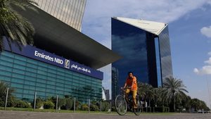 A man rides a bicycle past Emirates NBD head office in Dubai