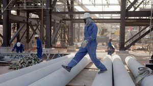 Walking over pipework during the construction of a new oil facility in the Sahara desert.