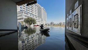 A volunteer uses a kayak to get down a flooded road in Dubai. Gulf insurers face mounting costs as extreme weather events become more frequent