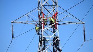 Workers on the high tension transmission lines performing maintenance