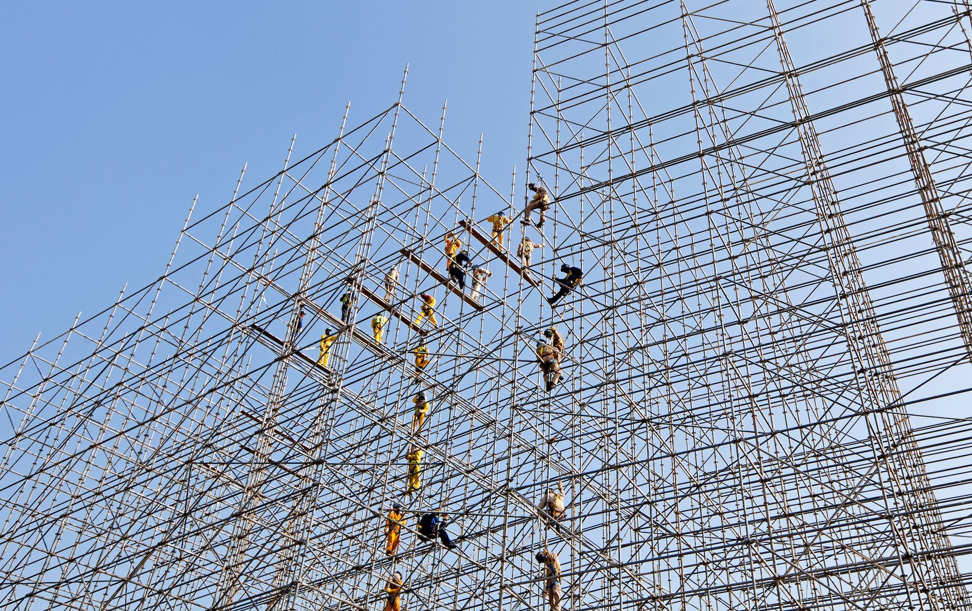 Construction workers erect scaffolding in Doha. Across the GCC, roads, railways, homes and hotels are being built