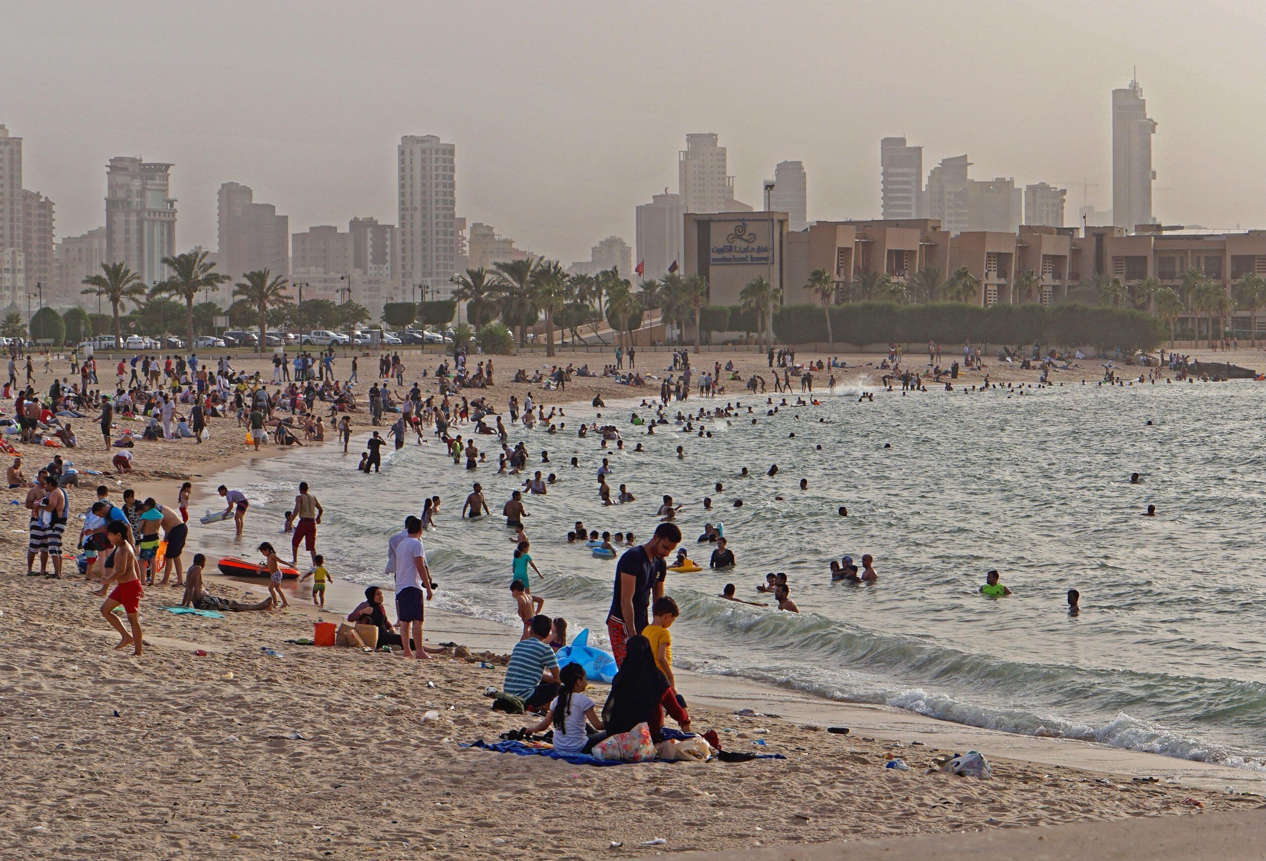 People enjoy Kuwait City's Marina beach. The IMF says Kuwait's public sector wages are around 40 percent higher than private sector wages