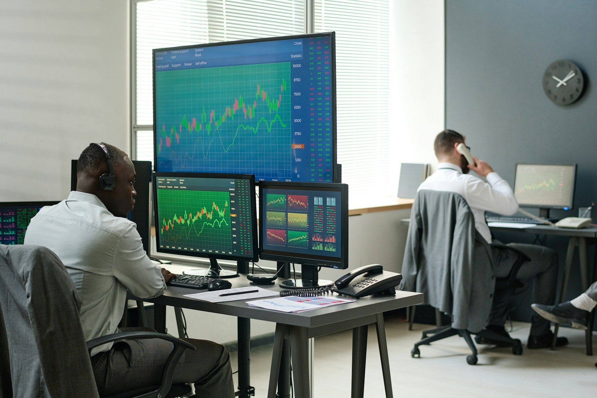 Two men working in finance at computers displaying charts. Derayah Financial CEO Mohammed AlShammas believes its listing will encourage other local and regional players to do the same